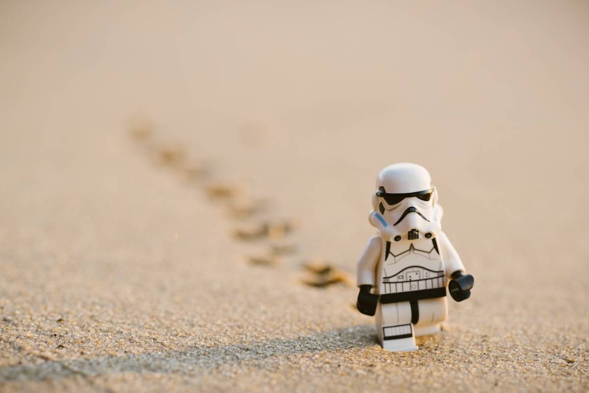 a little figure trooper walks on the sand
